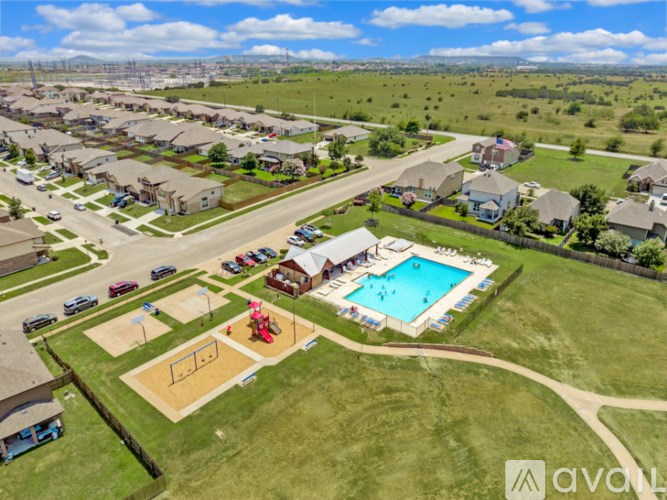 A bird's eye view of a suburban neighborhood with a swimming pool and a playground.