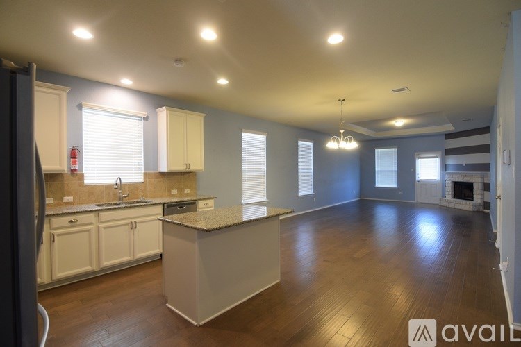 A kitchen with white cabinets and a granite countertop.