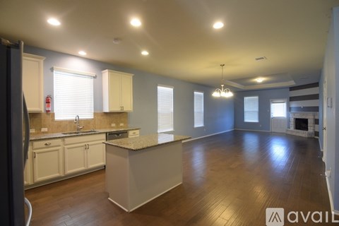 A kitchen with white cabinets and a granite countertop.