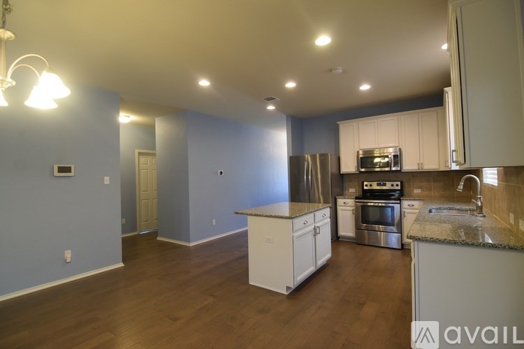 A kitchen with white cabinets and a stainless steel refrigerator.