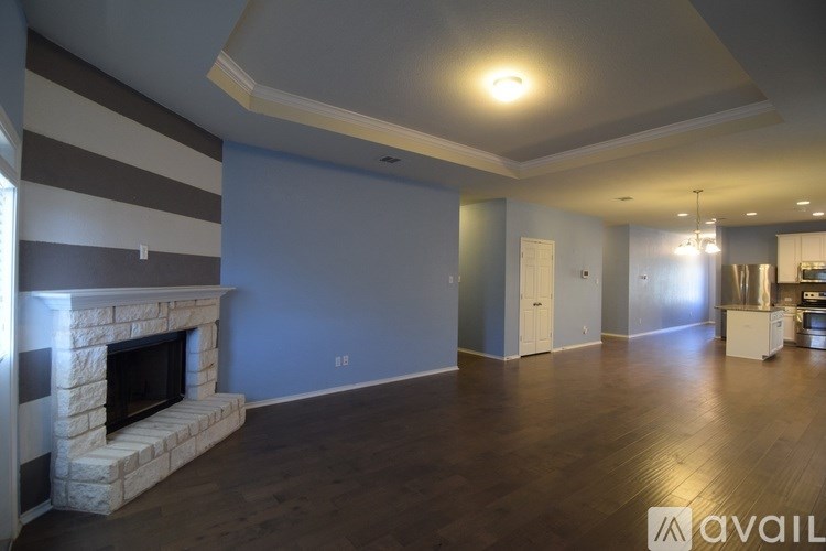 A living room with a fireplace and striped wallpaper.