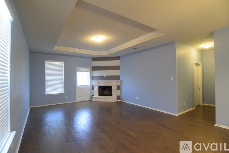 A spacious living room with a fireplace and striped curtains.