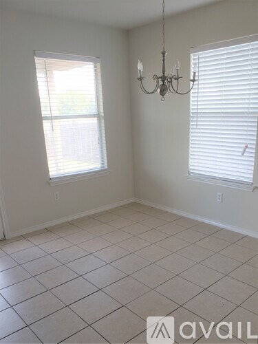 A room with a chandelier and two windows.