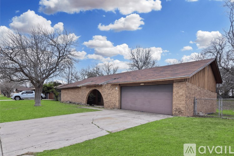 A house with a brown garage door and a grey car parked in front.