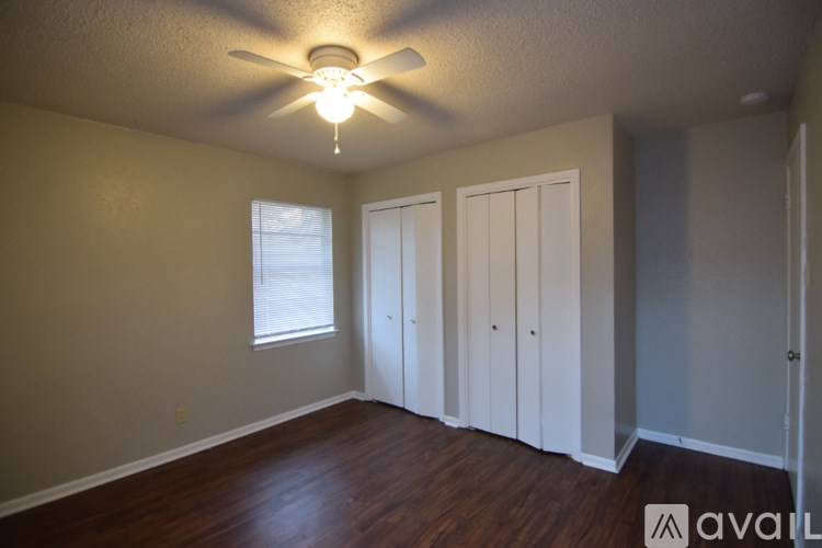 A room with a ceiling fan and three doors.