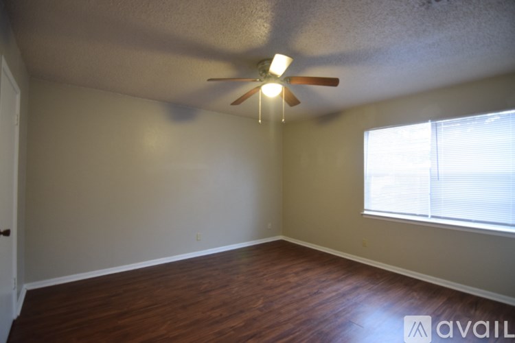 A room with a ceiling fan and a window with blinds.