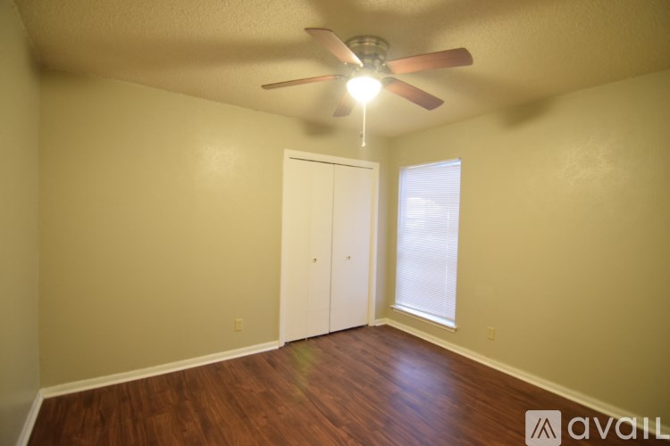 A room with a ceiling fan and a door.
