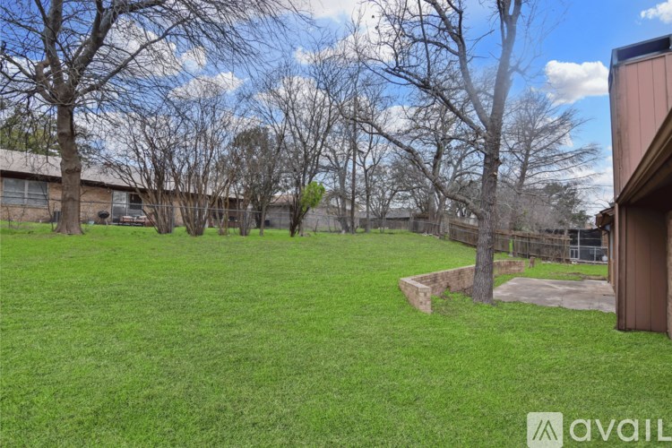 A backyard with a shed and a fence.