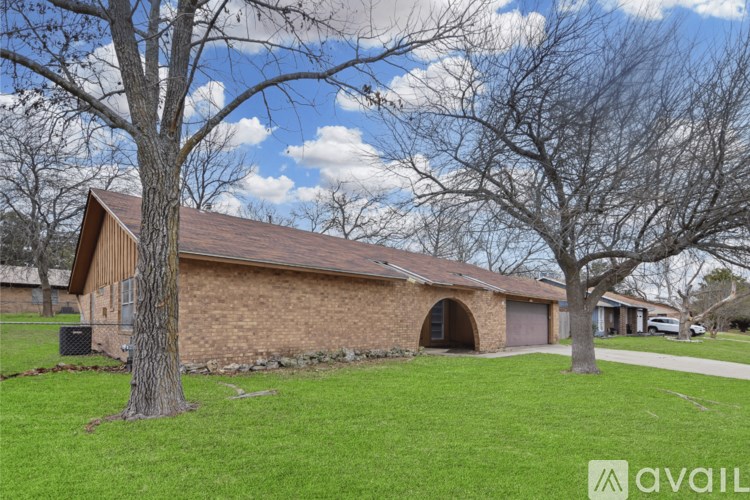 A house with a brown roof and a tree in front of it.