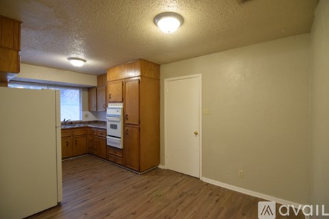 A kitchen with wooden cabinets and a white refrigerator.