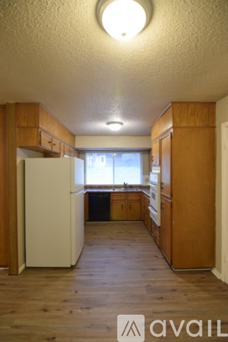 A kitchen with wooden cabinets and a white fridge.