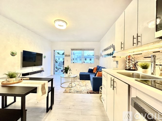 A modern kitchen with a dining table and a living area.