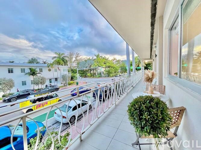 A balcony with a railing and a potted plant.