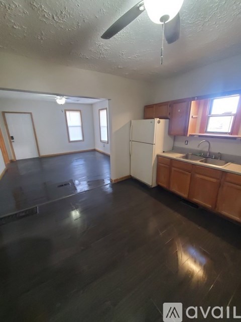 A kitchen with wooden cabinets and a white refrigerator.