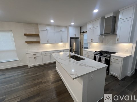 A modern kitchen with white cabinets and a large island.