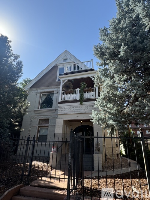 A house with a white facade and a black gate.
