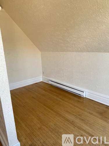 A room with wooden flooring and white walls.
