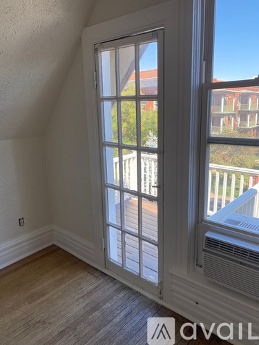 A room with a large window and a view of a building outside.