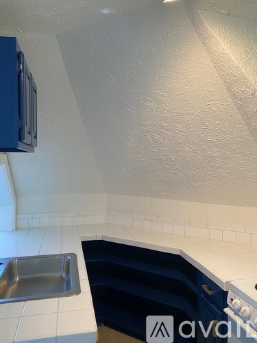 A kitchen with a blue cabinet and a white sink.