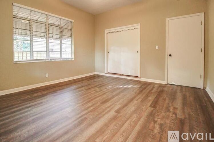 A room with wooden flooring and two doors.