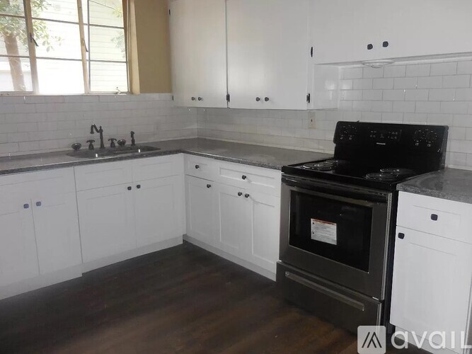 A kitchen with white cabinets and a refrigerator.