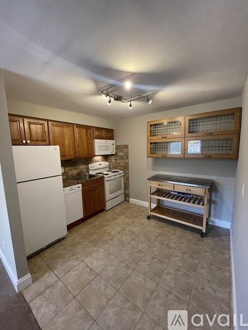 A kitchen with white appliances and wooden cabinets.