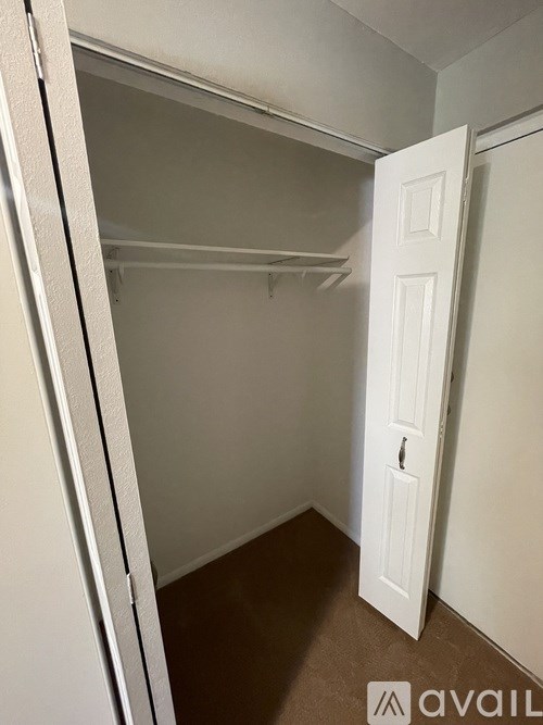 A white door is open to a small, empty room.