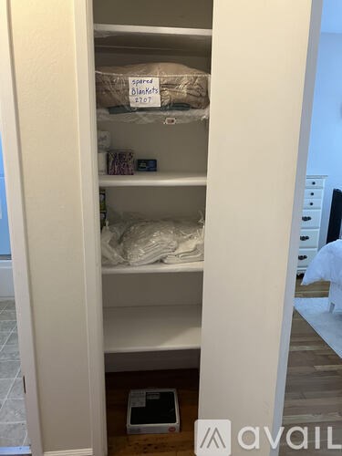 A small closet with a sign that says "Spares Blankets 107".