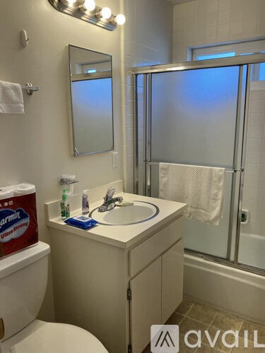 A bathroom with a white toilet, sink, and mirror.