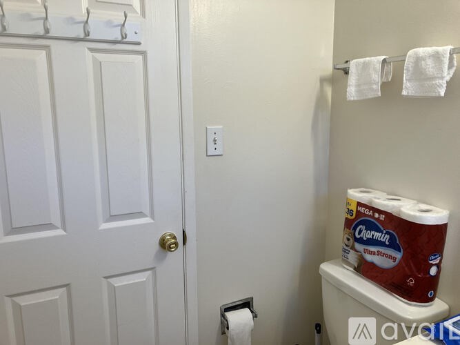 A white door with a towel rack and towels hanging on it.