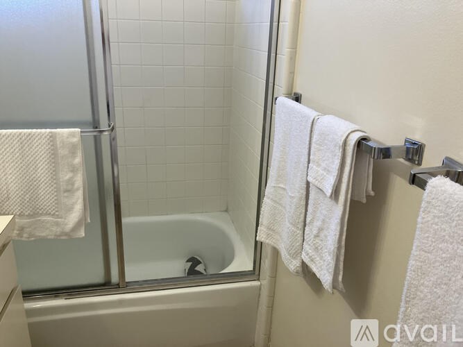 A white towel hangs on a towel rack in a bathroom.
