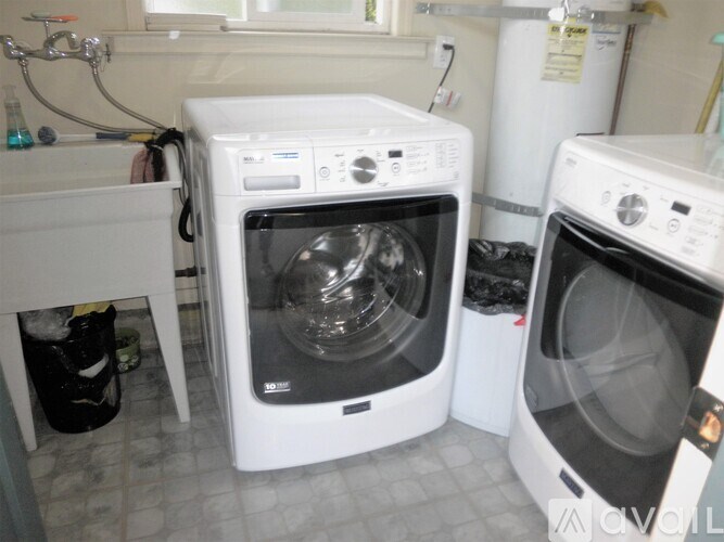 A white front loading washing machine is in a laundry room.