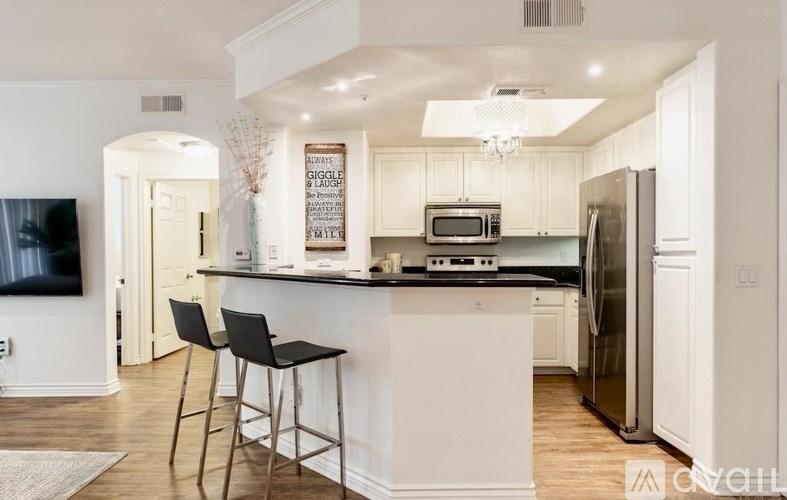A kitchen with white cabinets and a black countertop.
