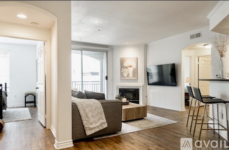 A living room with a couch, a fireplace, and a television.