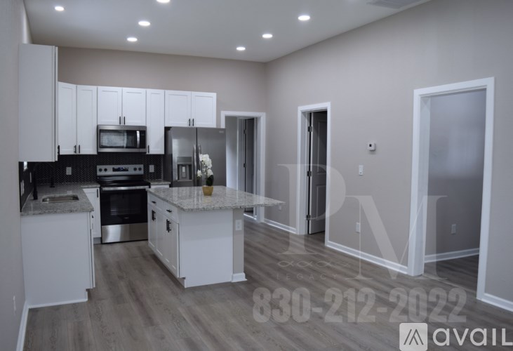 A modern kitchen with white cabinets and a black stove top oven.