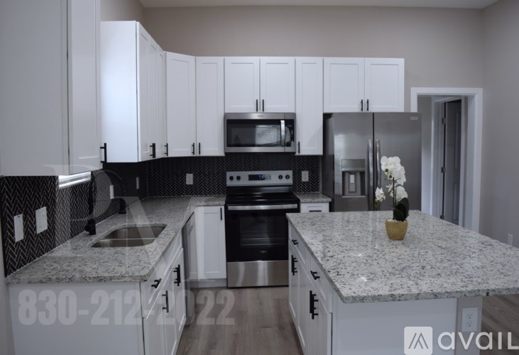 A kitchen with granite countertops and white cabinets.