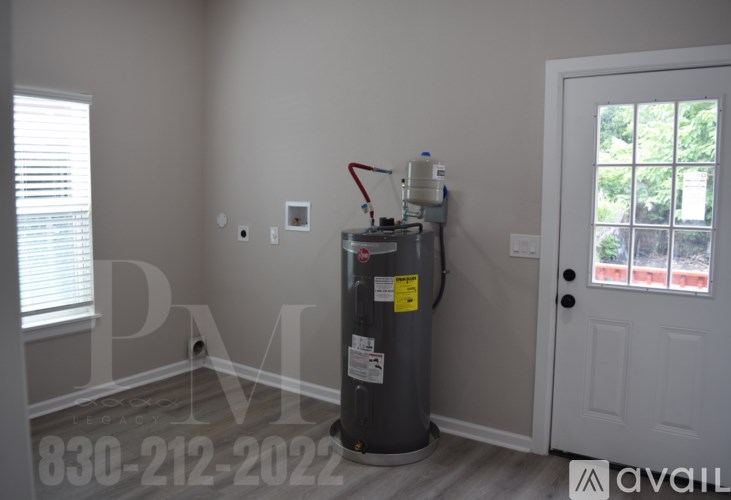 A room with a water heater and a window.