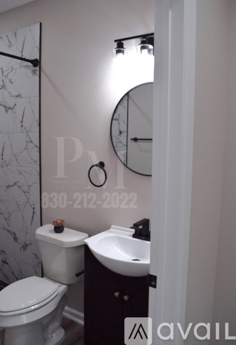 A bathroom with a toilet, sink, and a clock on the wall.