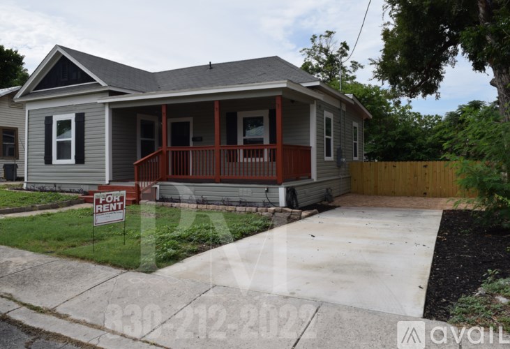 A house with a porch and a sign that says "For Rent".