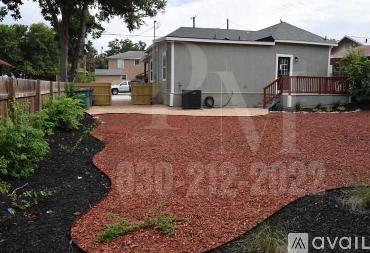 A red mulch pathway leads to a house with a grey roof.