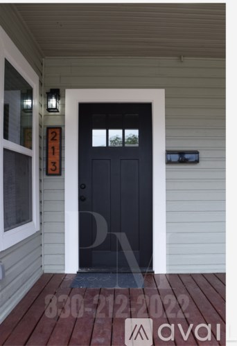 A black door with a white frame and a number 213 on the wall.