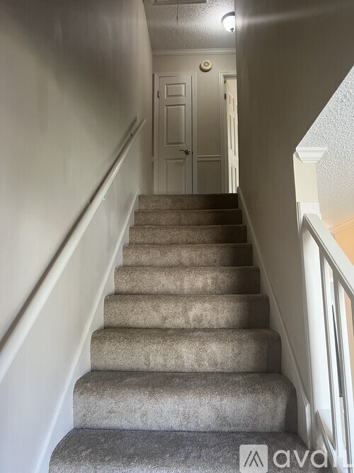 A staircase with a carpeted runner and a wooden banister.