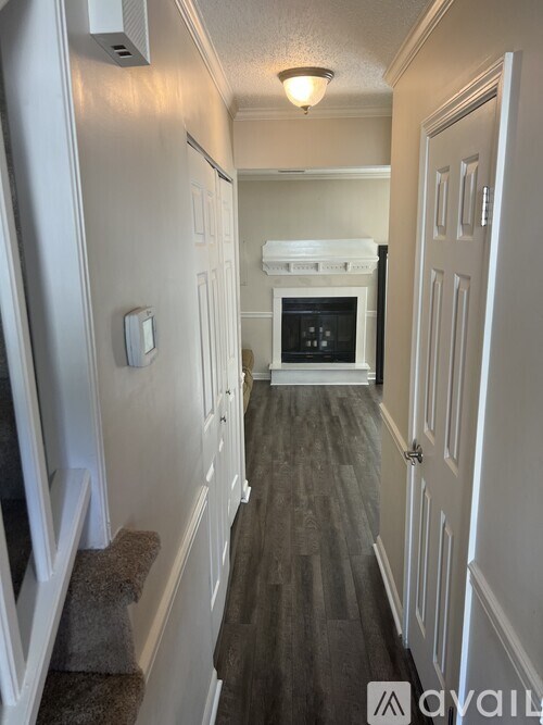 A hallway with a white door and a white wall.