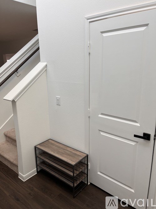 A white door is on the right and a staircase on the left.