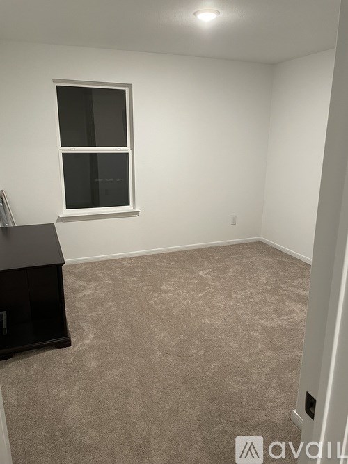 A room with a carpeted floor and a window.