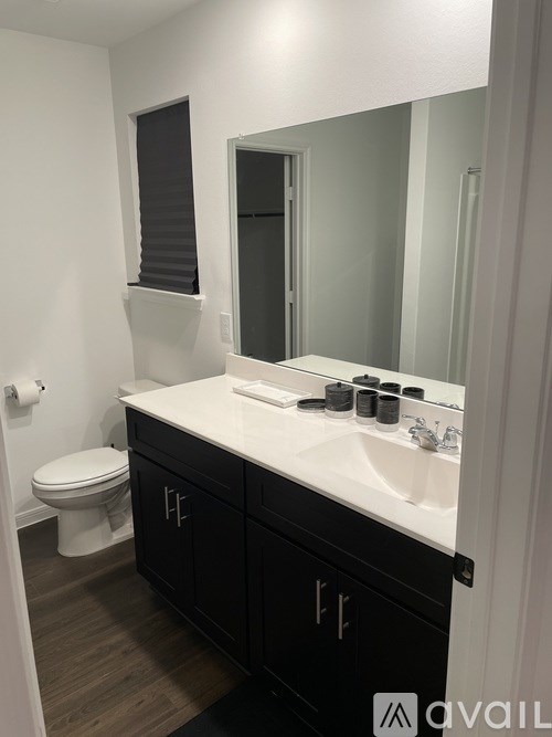 A bathroom with a white sink and black cabinets.
