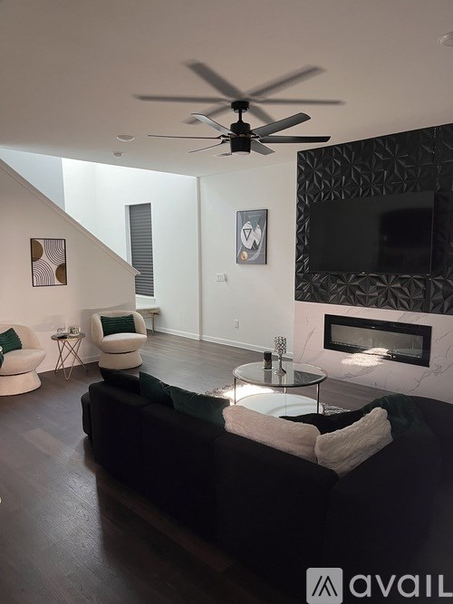 A living room with a black couch and a fireplace.