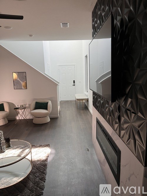 A modern living room with a black and white geometric wall design.