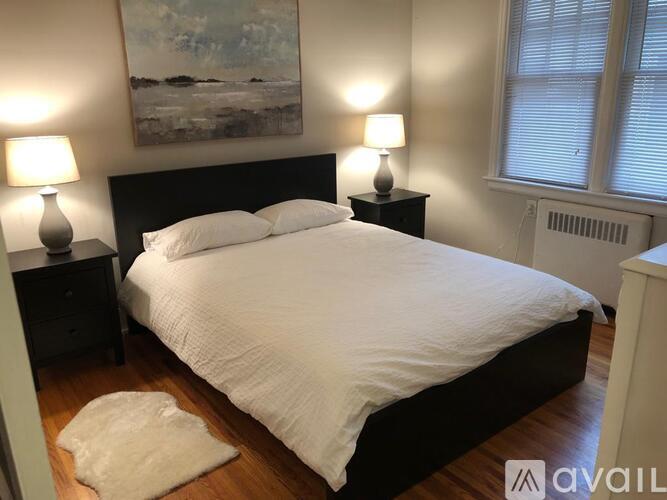 A bedroom with a large bed and two lamps on either side of it.