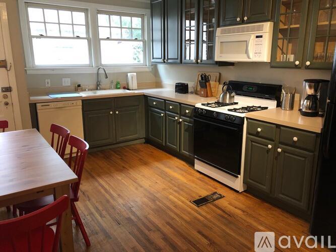 A kitchen with wooden floors and a white stove top oven.